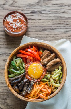 Ahşap masa üzerinde bibimbap kase