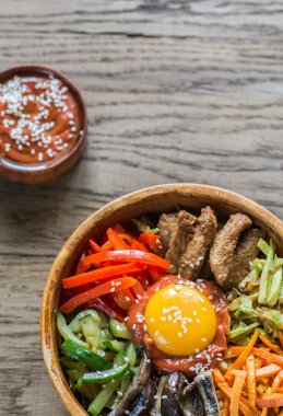 Ahşap masa üzerinde bibimbap kase