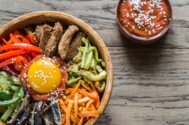 Ahşap masa üzerinde bibimbap kase