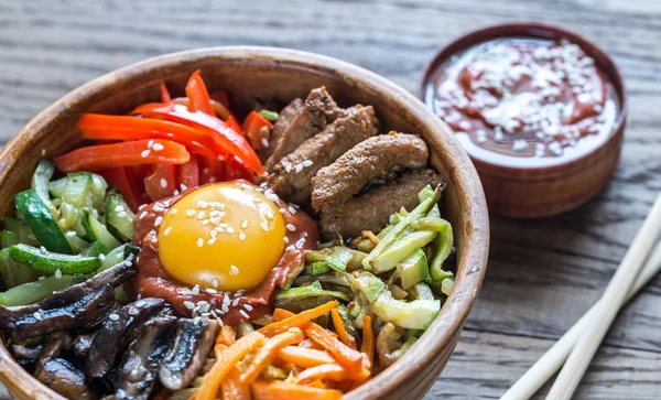Ahşap masa üzerinde bibimbap kase