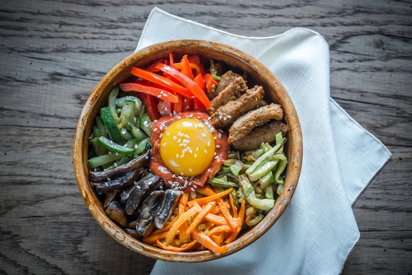 Ahşap masa üzerinde bibimbap kase