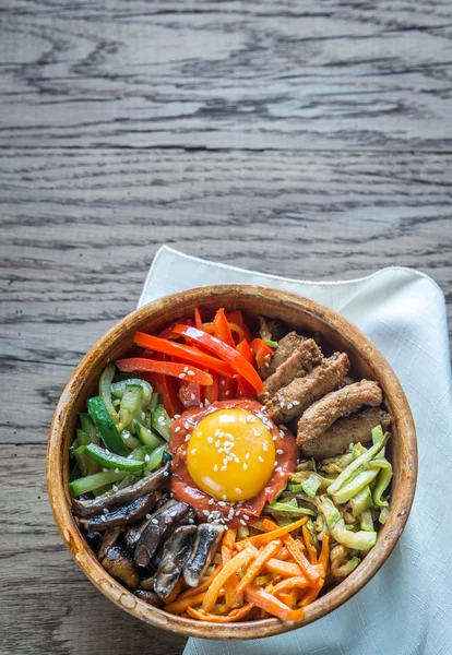 Ahşap masa üzerinde bibimbap kase