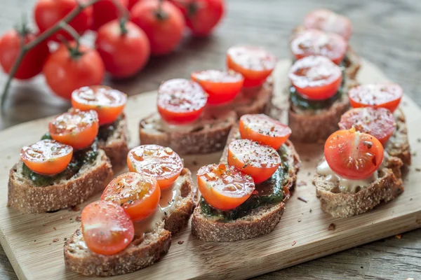 Toasts with tahini and mint sauce and cherry tomatoes — Stock Photo, Image