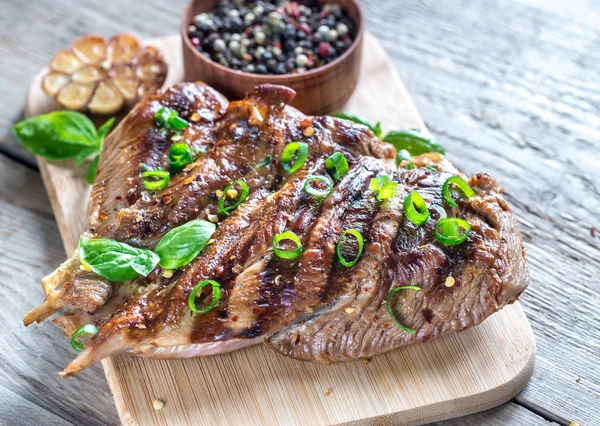 Gegrilde kalkoen met groene lente-ui op het houten bord — Stockfoto