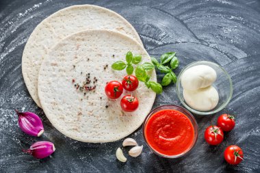 Koyu ahşap arka plan üzerinde pizza malzemeleri