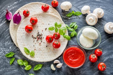 Koyu ahşap arka plan üzerinde pizza malzemeleri