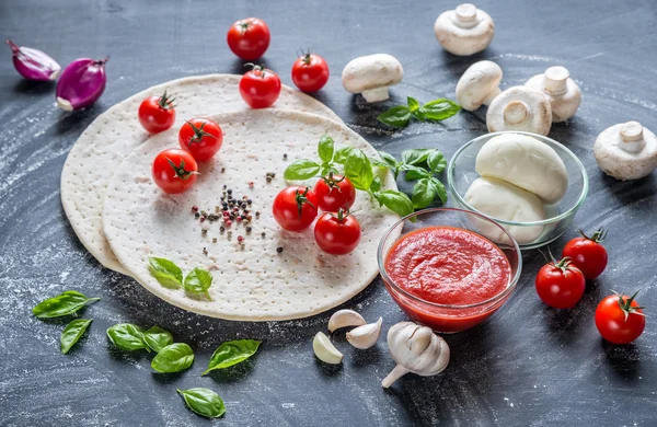 Pizza ingredients on the dark wooden background — Stock Photo, Image