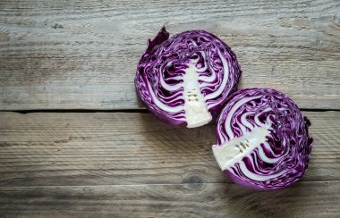 Ahşap arka plan üzerinde kırmızı lahana iki yarısı