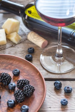 Ahşap masa üzerinde taze çilek ile kırmızı şarap