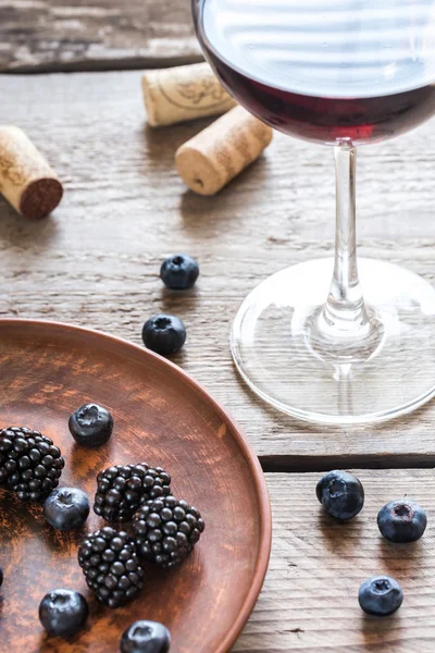 Glass of red wine with fresh berries on the wooden table — Stock Photo, Image