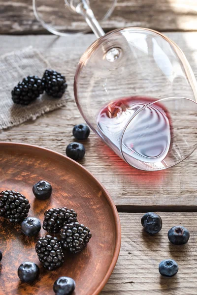 Glass of red wine with fresh berries on the wooden table — Stock Photo, Image