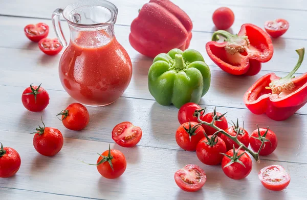 Świeże pomidory, papryka i dzbanek soku — Zdjęcie stockowe