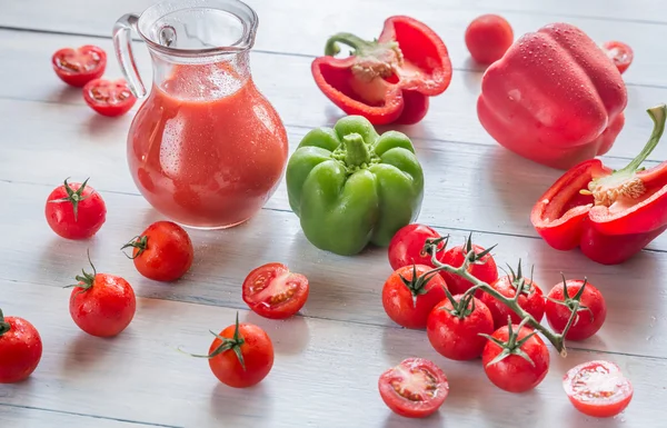 Tomates frescos, pimientos y jarra de jugo —  Fotos de Stock
