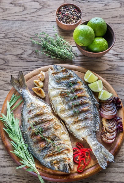 Dorade Royale pescado a la parrilla en el tablero de madera —  Fotos de Stock