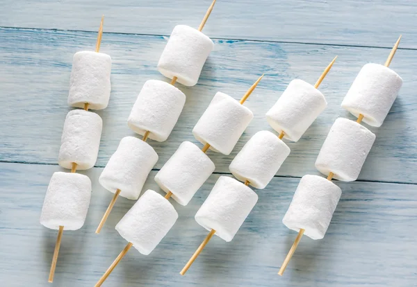 Pinchos de malvavisco en el fondo de madera — Foto de Stock