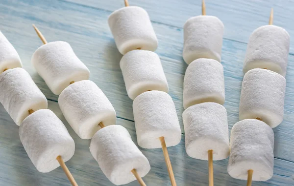 Pinchos de malvavisco en el fondo de madera — Foto de Stock