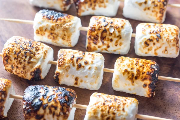 Marshmallow skewers on the wooden background — Stock Photo, Image