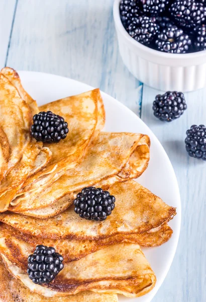 Crepes com amoras na mesa de madeira — Fotografia de Stock