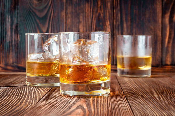 Glasses of Southern comfort on the rocks on wooden background