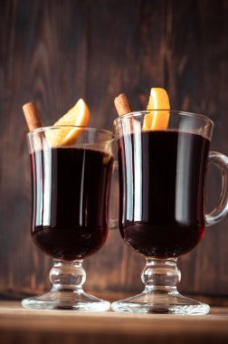 Tarçın ve portakalla süslenmiş sıcak şarap kadehleri.