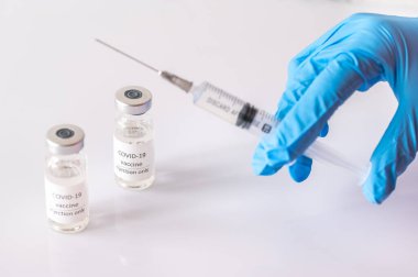 Doktor Coronavirus aşı tüpünden ilaç alıyor.