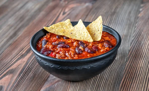 Bowl of chili con carne on a wooden table