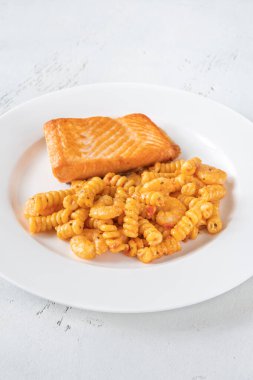 Bir porsiyon karides ve somon filetosu ile soslu makarna.