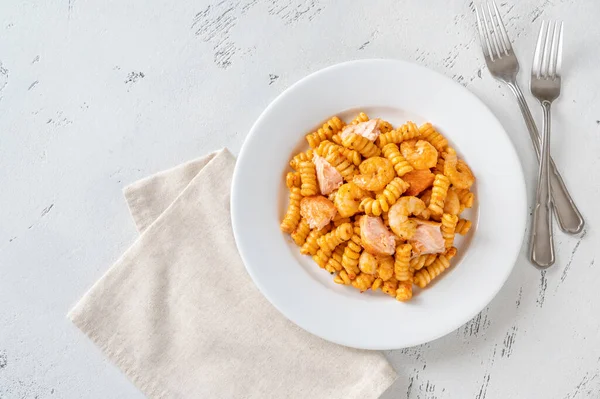 Bir porsiyon karides ve somon filetosu ile soslu makarna.