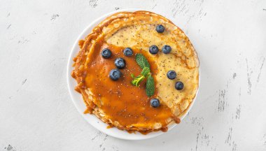 Karamel ve taze yaban mersinli ev yapımı krep yığını.