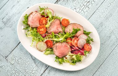 Servis tabağında biftek salatası.