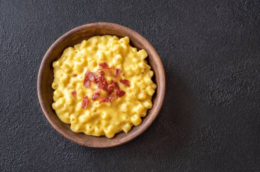 Bir kase peynirli makarna ve kızarmış pastırma.