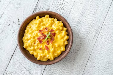 Bir kase peynirli makarna ve kızarmış pastırma.