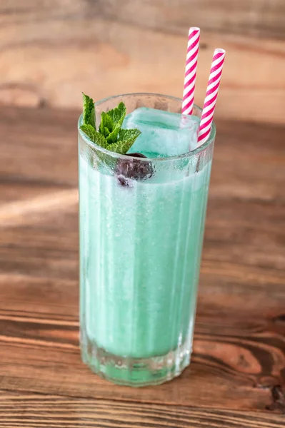 Glass of Blue Hawaiian cocktail on wooden background