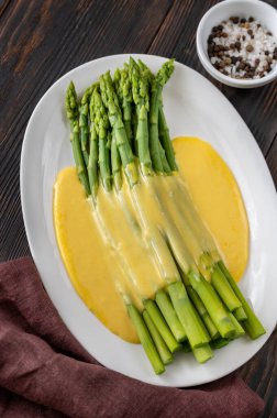 Servis tabağında Hollandaise soslu kuşkonmaz.