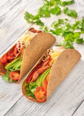 Servis tabağında jambonlu ve sebzeli taco.