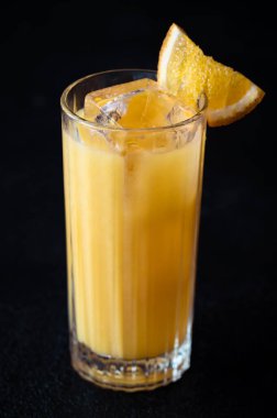 Portakal suyu ve siyah arka planda votka içeren tornavida kokteyli.