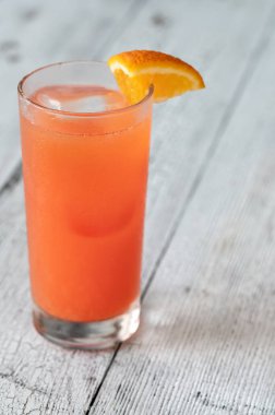 Turuncu kamayla süslenmiş bir bardak Alabama kokteyli.