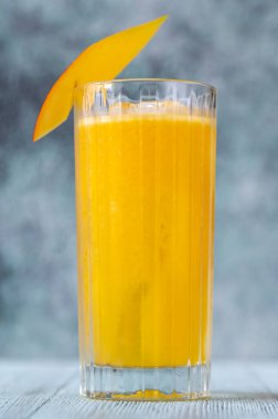 Bir bardak taze mangoyla süslenmiş Mango Rom Soğutucu kokteyli.