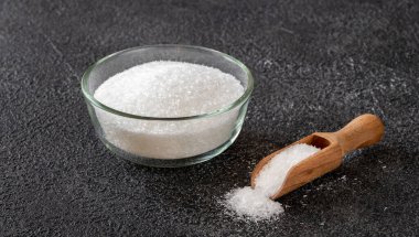 Siyah arka planda cam kase Monosodium glutamate.