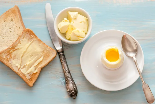 Вареное яйцо с хрустящими тостами на деревянном столе — стоковое фото