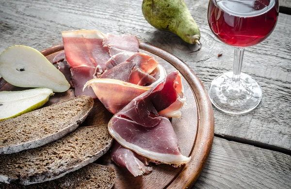 Fette di prosciutto italiano sul tagliere di legno — Foto Stock