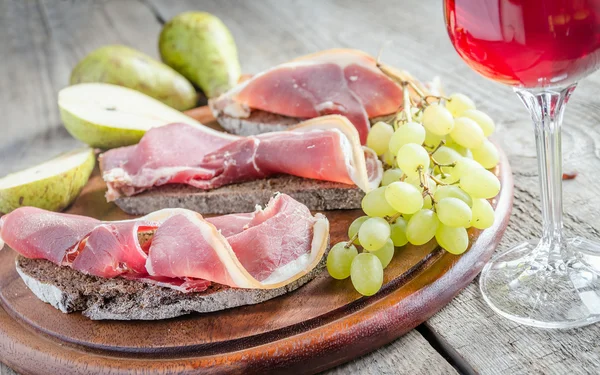 Segmenten van Italiaanse ham op het houten bord — Stockfoto