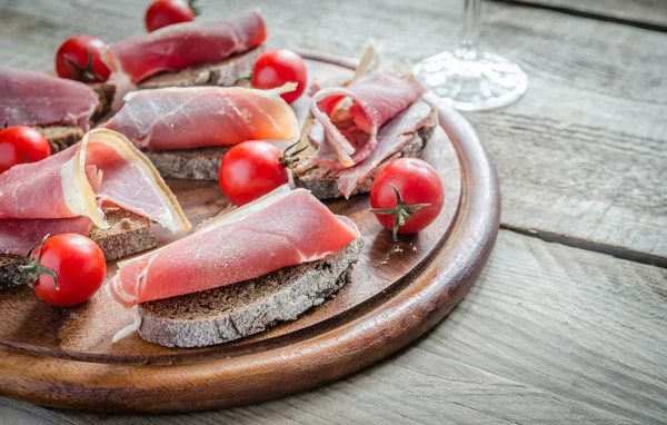 Scheiben italienischer Schinken auf dem Holzbrett — Stockfoto