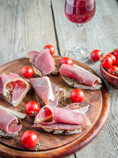 Ahşap tahta üzerinde İtalyan jambon dilimleri — Stok fotoğraf