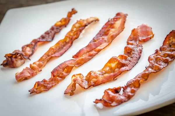 Stekt bacon strips på fyrkantiga plattan — Stockfoto