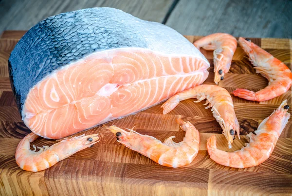 Rauwe zalm en garnalen op de houten bord — Stockfoto