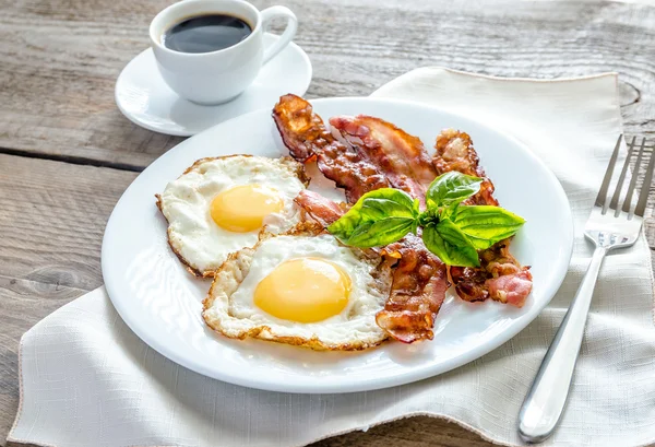 Sázená vejce s anglickou slaninou na dřevěný stůl — Stock fotografie