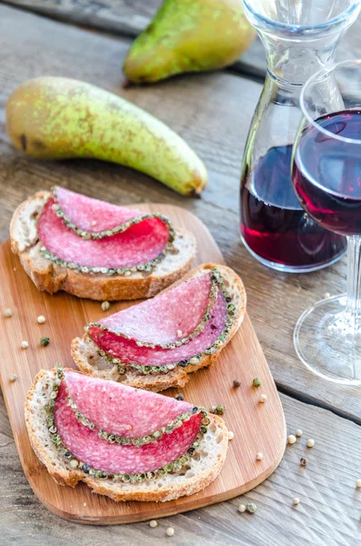 Segmenten van Italiaanse salami met peren en wijn — Stockfoto