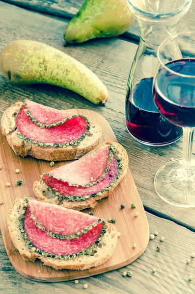 Segmenten van Italiaanse salami met peren en wijn — Stockfoto