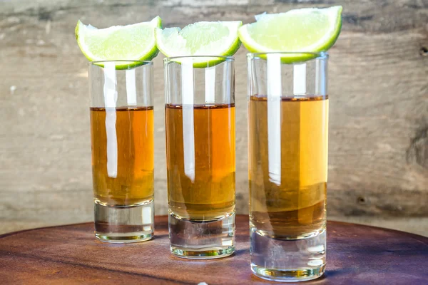 Glasses of tequila on the wooden board — Stock Photo, Image